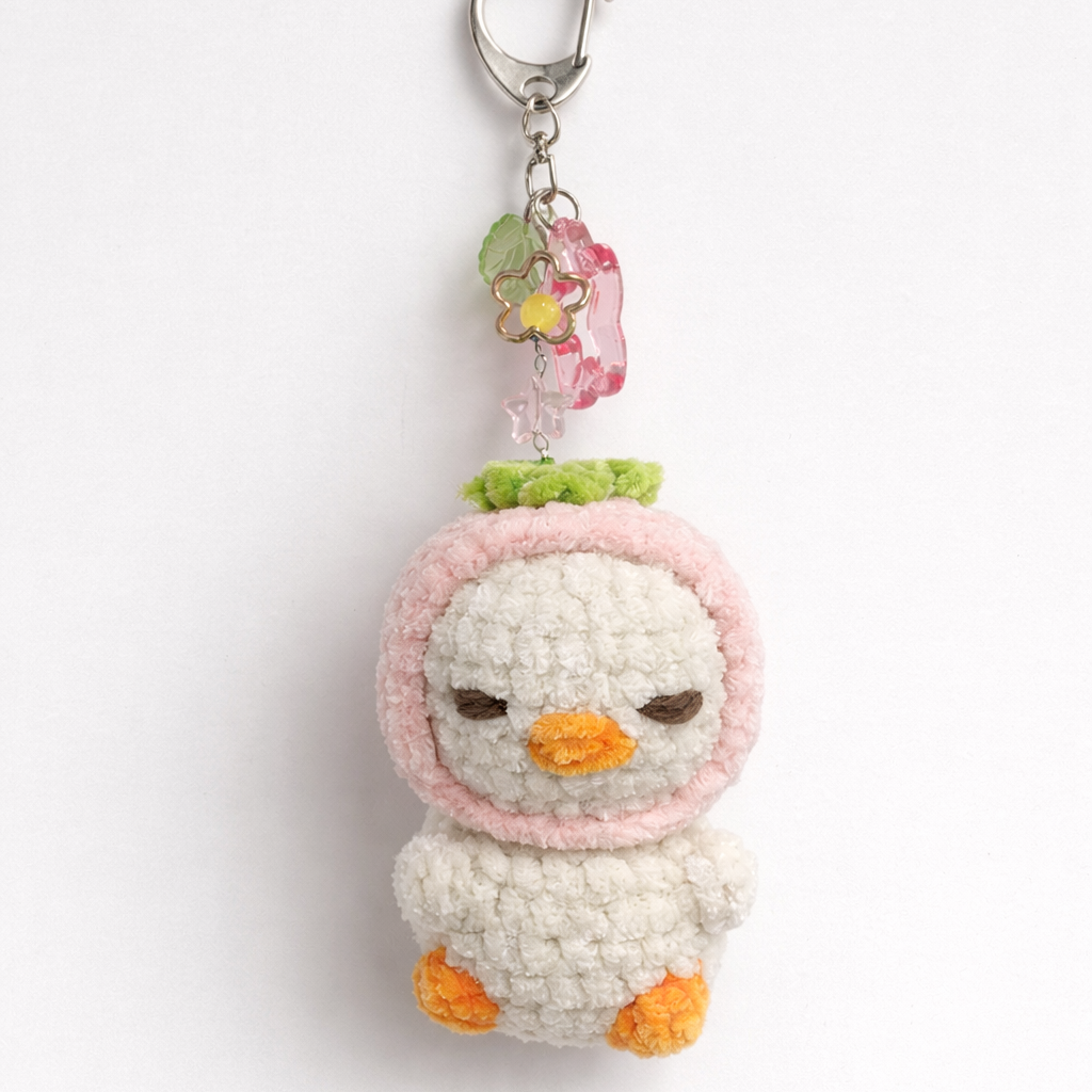 Crocheted duck keychain with a pink bow 